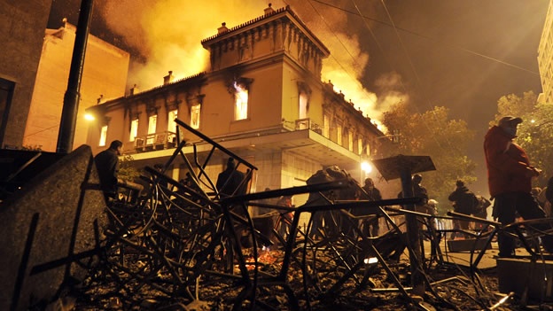 Foto de febrero de 2012, en Atenas. Decenas de negocios fueron saqueados o incendiados. El ayuntamiento de Atenas ofreció ayuda a los afectados durante protestas por los recortes (Foto: AFP).